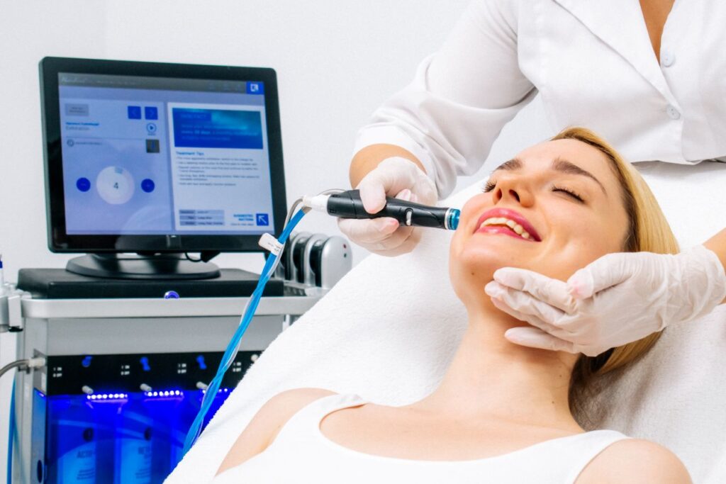 Anwendung der Hydrafacial Behandlung durch Fachkraft mit modernem Hautpflegegerät in professionellem Studio