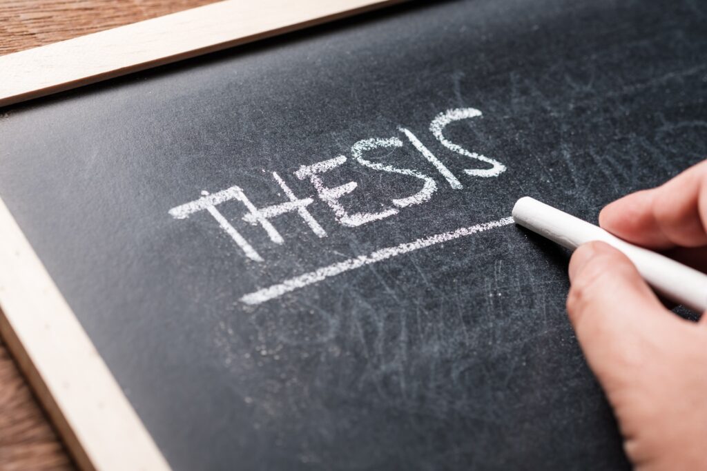 Wort Thesis auf Kreidetafel geschrieben | Ghostwriter Masterarbeit